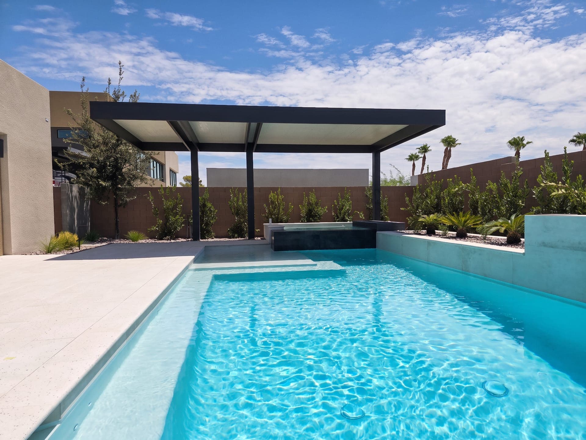 4K Aluminum cantilever cover with an insulated roof beside a modern pool and raised spa